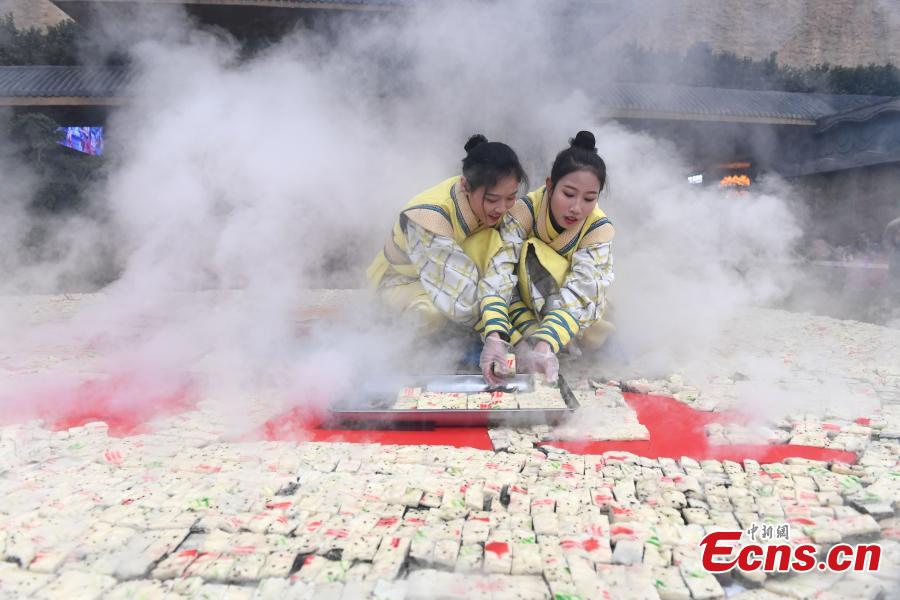 A steamer measuring eight meters in diameter and weighing two tons is used to cook sponge cake at a scenic area in Yichun City, East China\'s Jiangxi Province, Dec. 27, 2018. More than 88,000 pieces of cake were made and offered to tourists for free, along with wishes for success. The number 8 is considered lucky in Chinese culture because the pronunciation of \'eight\' in Mandarin Chinese is close to that of the phrase meaning \'to make a fortune\'. (Photo: China News Service/Chen Fei)