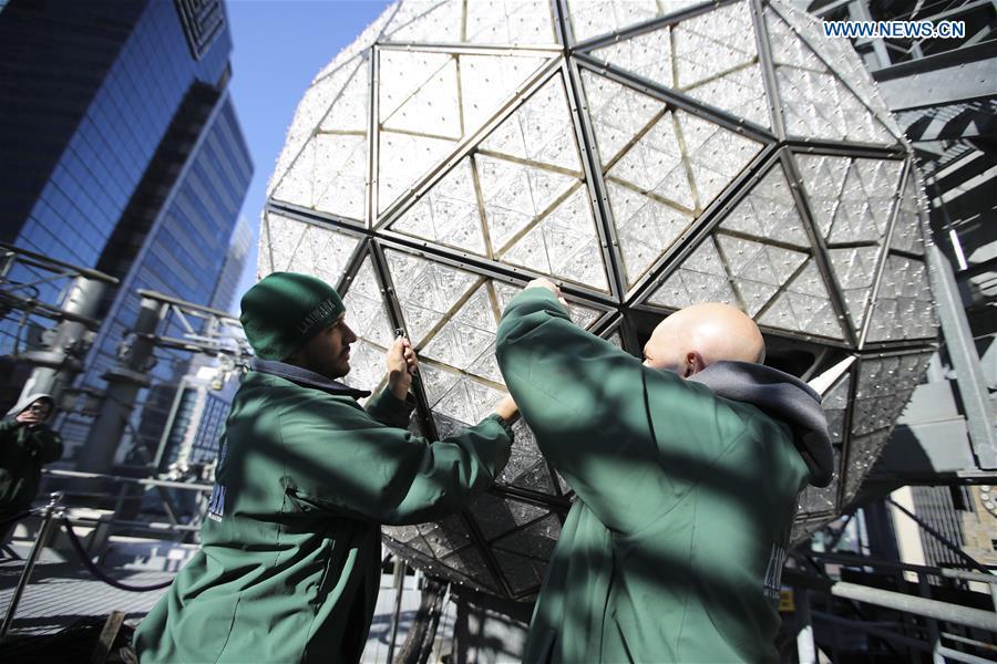 Workers install a panel with new crystal triangles onto the New Year\'s Eve Ball during a ceremony on the roof of the One Times Square building in New York City, the United States, on Dec. 27, 2018. The iconic New Year\'s Eve Ball at New York City\'s Times Square had its latest decoration done on Thursday for the upcoming celebrations. For Times Square 2019, 192 Waterford Crystal triangles introduce the new Gift of Harmony design of small rosette cuts flowing into each other in beautiful harmony. Covered with a total of 2,688 Waterford Crystal triangles, the ball is 12 feet (3.66 meters) in diameter and weighs 11,875 pounds (5386.4 kilograms). (Xinhua/Wang Ying)