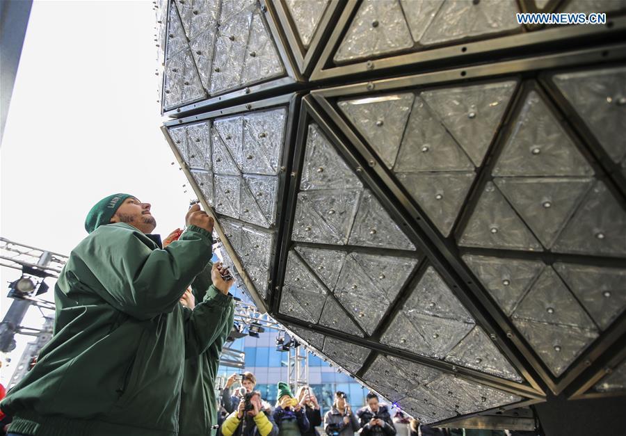 Workers install a panel with new crystal triangles onto the New Year\'s Eve Ball during a ceremony on the roof of the One Times Square building in New York City, the United States, on Dec. 27, 2018. The iconic New Year\'s Eve Ball at New York City\'s Times Square had its latest decoration done on Thursday for the upcoming celebrations. For Times Square 2019, 192 Waterford Crystal triangles introduce the new Gift of Harmony design of small rosette cuts flowing into each other in beautiful harmony. Covered with a total of 2,688 Waterford Crystal triangles, the ball is 12 feet (3.66 meters) in diameter and weighs 11,875 pounds (5386.4 kilograms). (Xinhua/Wang Ying)