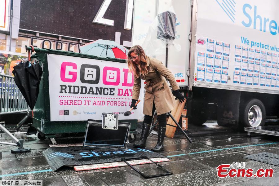 Allison Hagendorf mashes computer parts with a hammer during the National Good Riddance day ceremonial shredding of bad memories of 2018 in Times Square in the Manhattan borough of New York, U.S., Dec. 28, 2018. (Photo/Agencies)