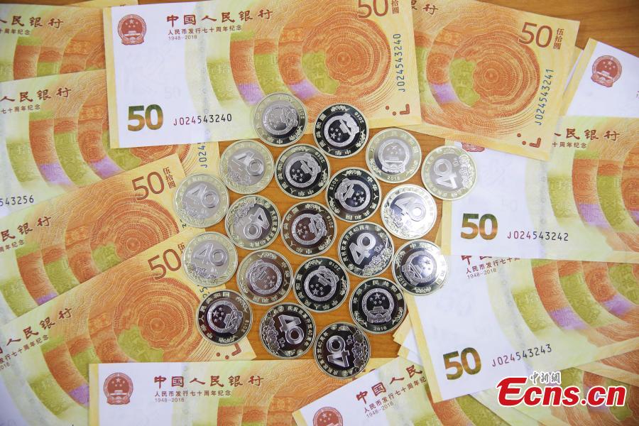 Photo taken on Dec. 28, 2018 shows banknotes and coins to commemorate the 70th anniversary of the establishment of the People\'s Bank of China and the 40th anniversary of the reform and opening-up respectively go on sale in Taiyuan City, North China\'s Shanxi Province. The 50-yuan commemorative banknote is 150 millimeters long and 70 millimeters wide, the same size as the regular 50-yuan banknote in the country\'s fifth set of notes. (Photo: China News Service/Zhang Yun)