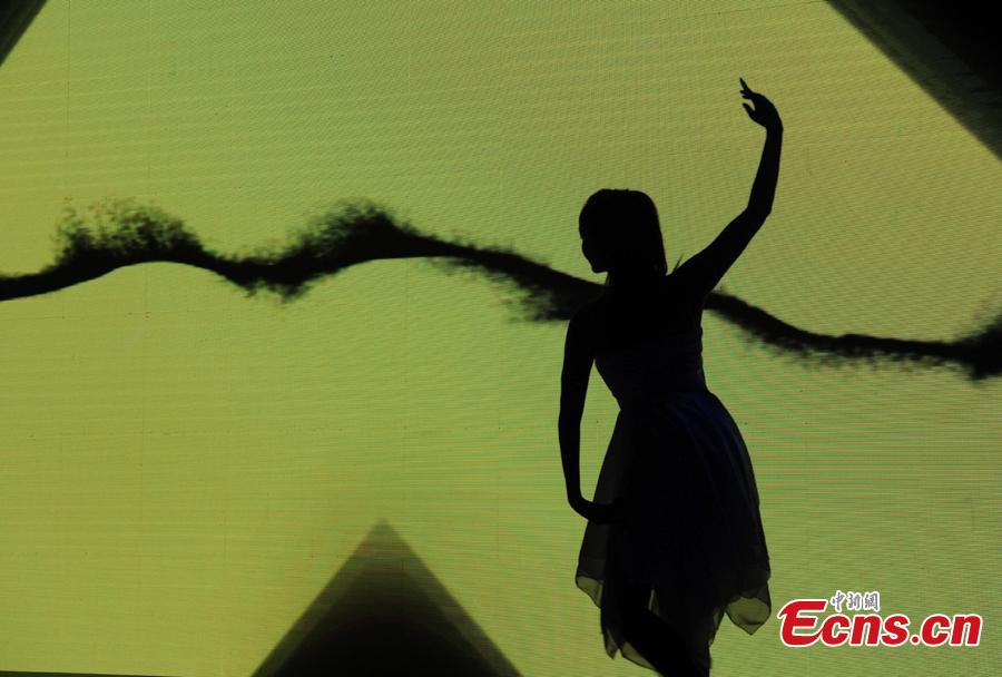 A dancer performs smart human-screen interaction at the finals of the First National Intelligent Sports Competition in Hangzhou, Zhejiang Province, Dec. 29, 2018. More than 1,400 finalists from across China will compete in 13 intelligent sports, including cycling, racing, golf, and shooting, in the following 2 days. (Photo: China News Service/Zhang Yin)