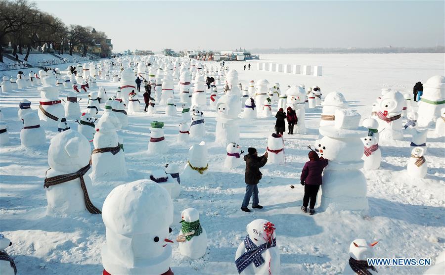 Aerial photo taken on Jan. 2, 2019 shows people viewing snowman sculptures on the riverbank of Songhua River in Harbin, capital of northeast China\'s Heilongjiang Province. Altogether 2,019 cute snowmen were displayed here to greet the year 2019. (Xinhua/Wang Jianwei)