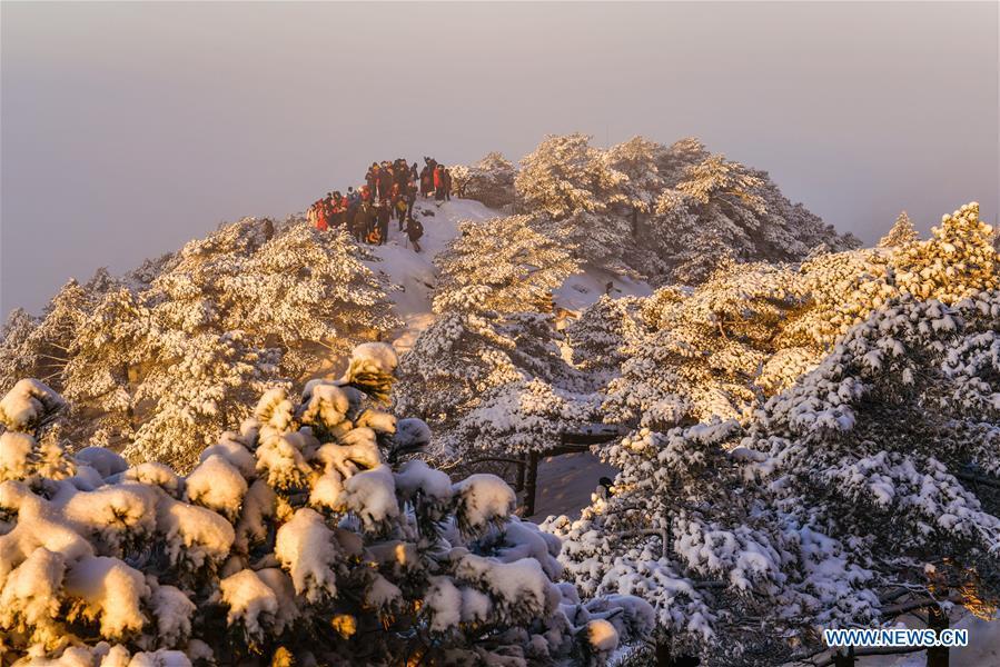 Visitors watch sunrise and clouds on the Huangshan Mountain in east China\'s Anhui Province, Dec. 31, 2018. (Xinhua/Shui Congze)