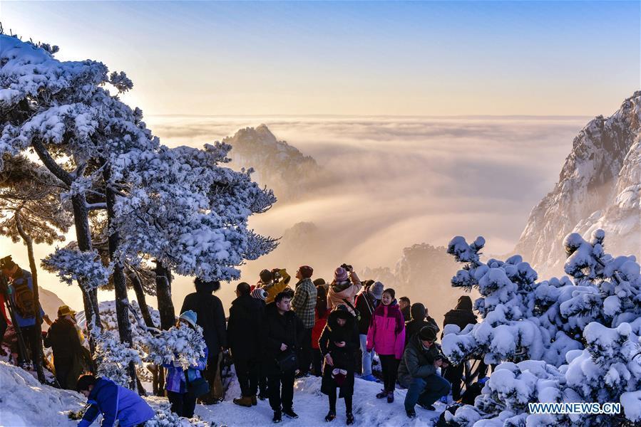 Visitors watch sunrise and clouds on the Huangshan Mountain in east China\'s Anhui Province, Dec. 31, 2018. (Xinhua/Shui Congze)