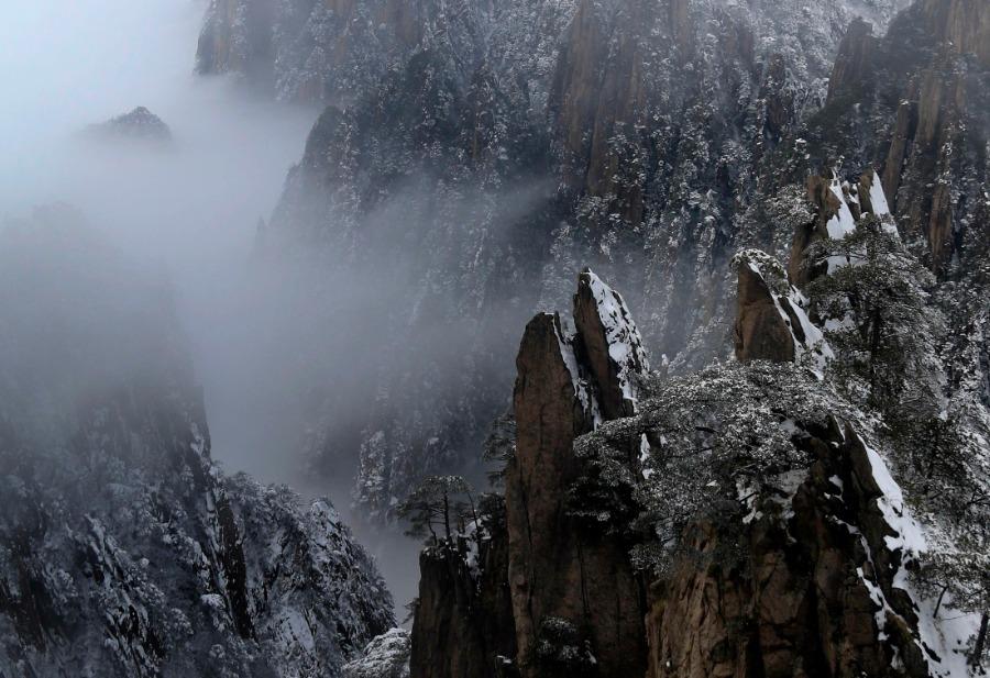 Huangshan Mountain scenic area in Anhui province is shrouded in a mantle of white after a snowfall, Jan. 1, 2019. Clouds and misty air envelop the towering mountain peaks, creating a breathtakingly beautiful scene. (Photo/Asianewsphoto)