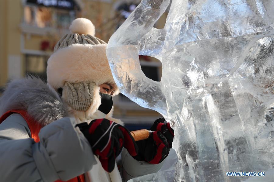 A contestant carves an ice sculpture on the Zhongyang Street during a national college ice sculpture competition in Harbin, capital of northeast China\'s Heilongjiang Province, Jan. 2, 2019. (Xinhua/Cao Jiyang)