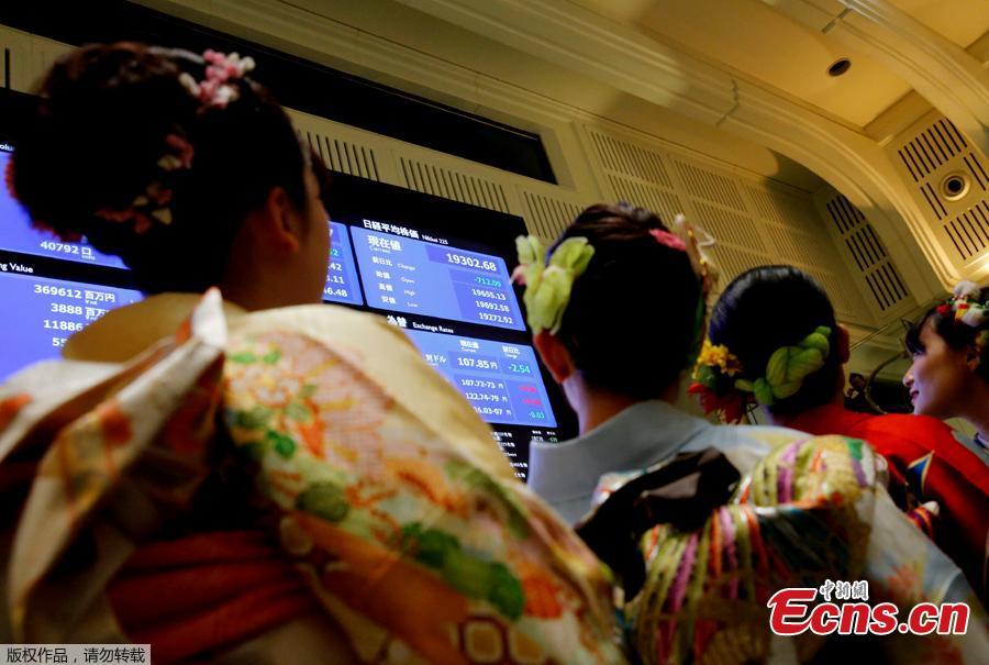 Women, dressed in ceremonial kimonos, pose in front of an electronic board showing stock prices after the New Year opening ceremony at the Tokyo Stock Exchange (TSE), held to wish for the success of Japan\'s stock market, in Tokyo, Japan, January 4, 2019. (Photo/Agencies)