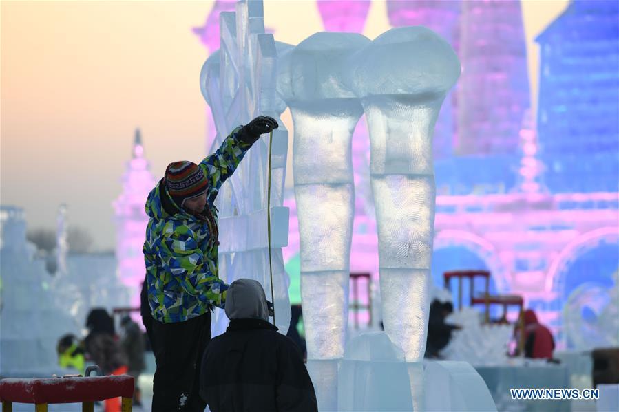 Contestants carve an ice sculpture during an international ice sculpture competition in Harbin, capital of northeast China\'s Heilongjiang Province, Jan. 3, 2019. (Xinhua/Wang Song)