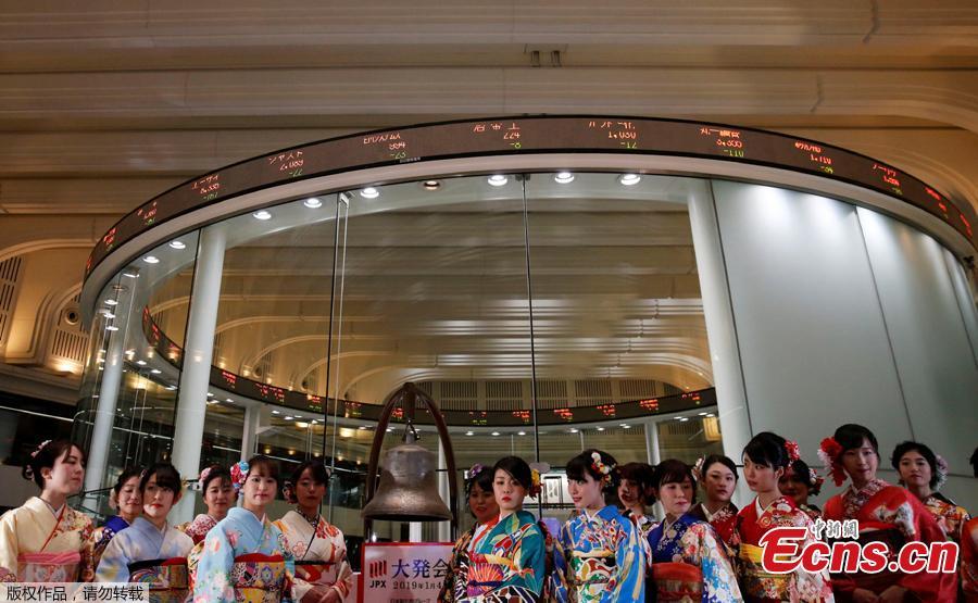Women, dressed in ceremonial kimonos, pose in front of an electronic board showing stock prices after the New Year opening ceremony at the Tokyo Stock Exchange (TSE), held to wish for the success of Japan\'s stock market, in Tokyo, Japan, January 4, 2019. (Photo/Agencies)