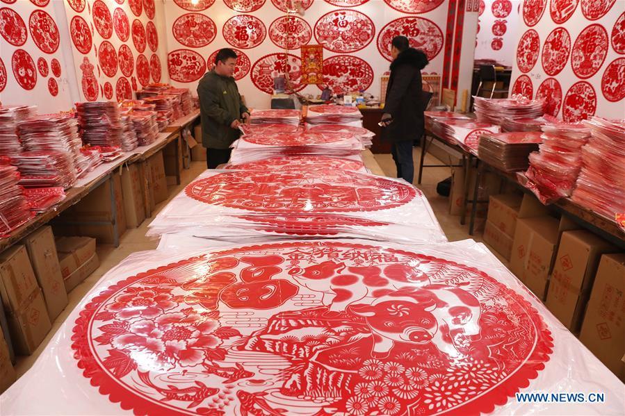 Customers select New Year goods at a market in Shijiazhuang, north China\'s Hebei Province, Jan. 6, 2019. People are busy buying decorations such as Spring Festival couplets and lanterns to greet the upcoming Lunar New Year. (Xinhua/Liang Zidong)