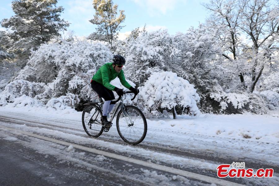 A cyclist rides his bike on the snow-covered Mount Parnitha, near Athens, Greece, Jan. 4, 2019. An elderly woman was found dead and two men were missing after blizzards hit parts of Greece, police officials said on Saturday. (Photo/Agencies)
