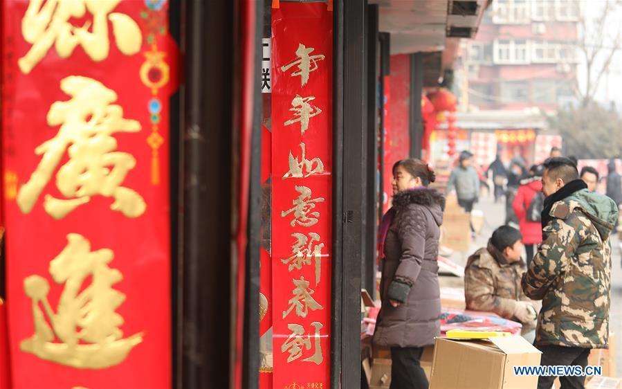 Customers select New Year goods at a market in Shijiazhuang, north China\'s Hebei Province, Jan. 6, 2019. People are busy buying decorations such as Spring Festival couplets and lanterns to greet the upcoming Lunar New Year. (Xinhua/Liang Zidong)