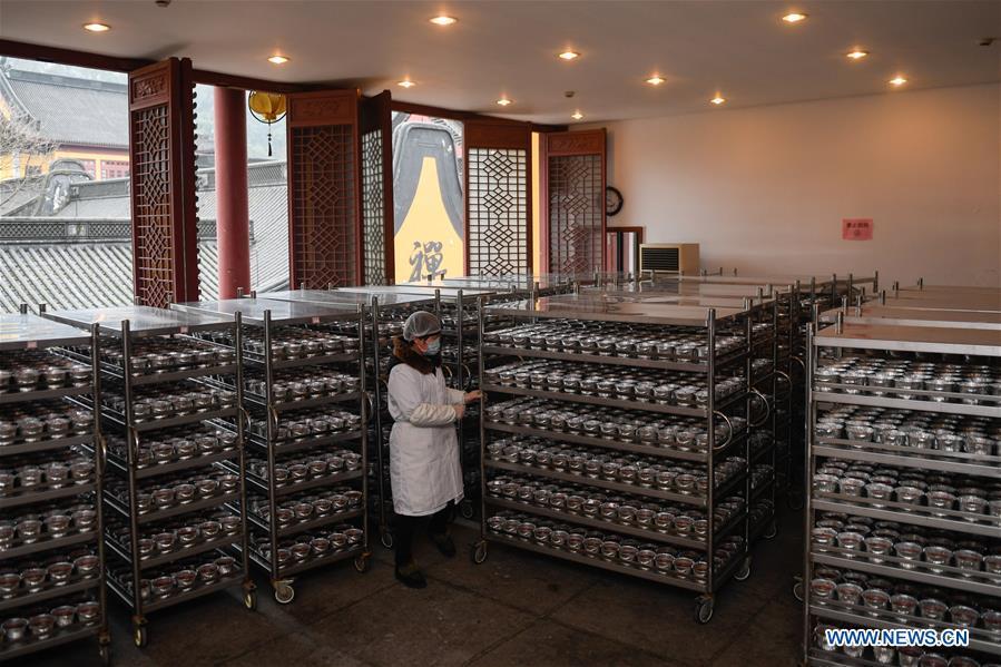 A volunteer shelves Laba porridge just cooked at Lingyin Temple in Hangzhou, capital of east China\'s Zhejiang Province, Jan. 6, 2019. Lingyin Temple started to make the traditional Laba porridge on Sunday, which was the first day of the 12th month of the Chinese lunar calendar, and will share it with local community for free. (Xinhua/Huang Zongzhi)