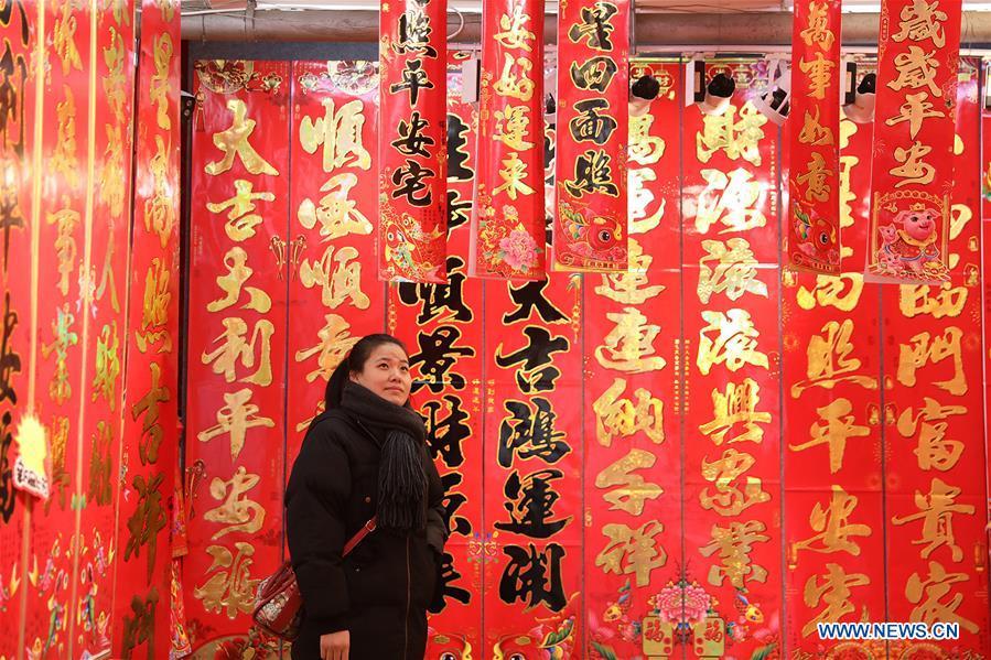 A customer selects New Year goods at a market in Shijiazhuang, north China\'s Hebei Province, Jan. 6, 2019. People are busy buying decorations such as Spring Festival couplets and lanterns to greet the upcoming Lunar New Year. (Xinhua/Liang Zidong)