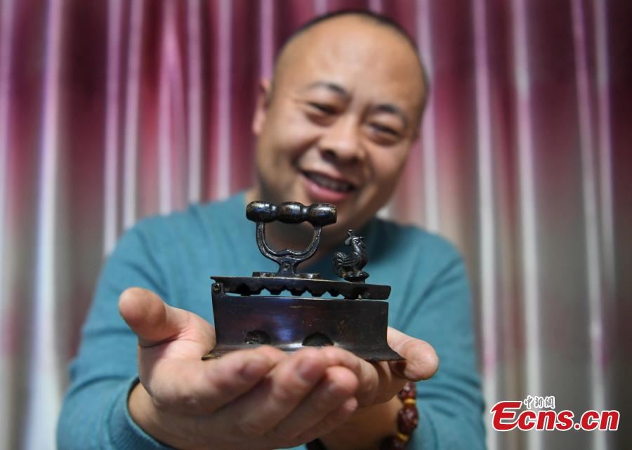 Teng Yongshan of Jilin City in Jilin Province shows his collection of irons - a collection he began in 2000. The former teacher has collected more than 40 irons that were made during the Jin (1115-1234) to Qing Dynasties (1368-1644) and in the early Republic period. Some of the irons were imported into China, including some from Japan and Germany. (Photo: China News Service/Zhang Yao)