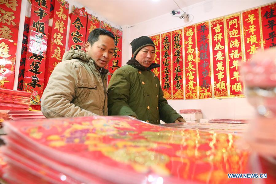 A seller arranges newly arrived Spring Festival couplets at a market in Shijiazhuang, north China\'s Hebei Province, Jan. 6, 2019. People are busy buying decorations such as Spring Festival couplets and lanterns to greet the upcoming Lunar New Year. (Xinhua/Liang Zidong)