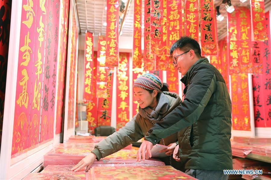 Customers select New Year goods at a market in Shijiazhuang, north China\'s Hebei Province, Jan. 6, 2019. People are busy buying decorations such as Spring Festival couplets and lanterns to greet the upcoming Lunar New Year. (Xinhua/Liang Zidong)
