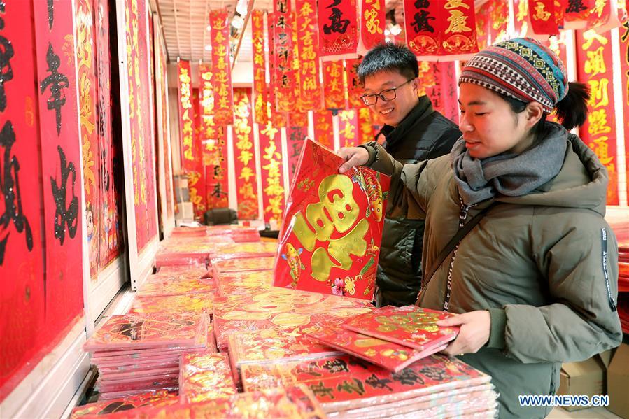 Customers select New Year goods at a market in Shijiazhuang, north China\'s Hebei Province, Jan. 6, 2019. People are busy buying decorations such as Spring Festival couplets and lanterns to greet the upcoming Lunar New Year. (Xinhua/Liang Zidong)