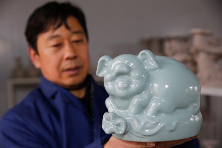 A Ru porcelain pig is shown at the studio of Wang Guoqi in Baofeng county, Pingdingshan city, Central China\'s Henan Province, Jan. 7, 2019. Pig-themed porcelain works are being made there as New Year mascots to welcome the upcoming Year of the Pig in the lunar Chinese calendar. The lunar New Year falls on Feb 5 this year. (Photo/Asianewsphoto)
