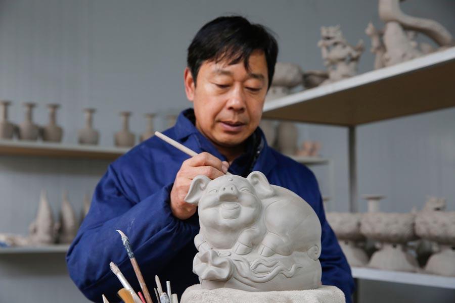 Craftsman Wang Guoqi works on the base of a Ru porcelain pig in Baofeng county, Pingdingshan city, Central China\'s Henan Province, Jan. 7, 2019. Wang is an inheritor of Ru porcelain, one of China\'s \