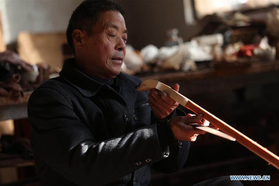 Villager Gao Zhenbao checks the pole of Erhu, a Chinese two-stringed bowed instrument at Yuequan Village of Miaoshan Town in Linyi City, east China\'s Shandong Province, Jan. 8, 2019. Yuequan is famous for its time-honored handmade Erhu, with more than 90 households dedicated to it in the village. (Xinhua/Zhang Chunlei)