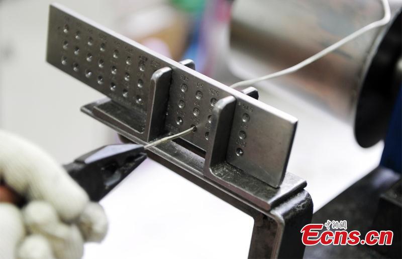 Artisans use silver thread to make crafts in Chengdu City, Southwest China\'s Sichuan Province. The craft dates back to the Song Dynasty (960-1279) and involves time-consuming, elaborate steps to pull a one-meter silver piece into a 1000-meter thin thread, which is then used to make all kinds of handmade works. In 2008, the craft was included as a national intangible cultural heritage. (Photo: China News Service/Zhong Xin)