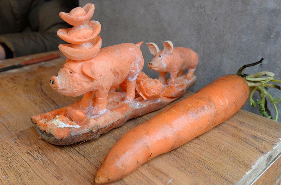An ordinary carrot and a sculpture made of the same material by Guo Yuhong, a vegetable vendor. (Photo by Hao Qunying for chinadaily.com.cn)