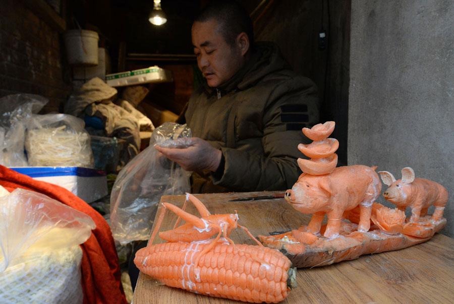 Sculptures carved out of carrots by Guo Yuhong, a Hebei vegetable vendor.  (Photo by Hao Qunying for chinadaily.com.cn)