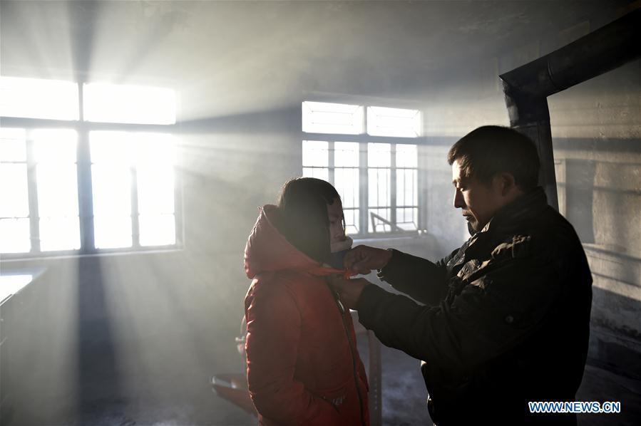 Hu Zhisheng helps his student Sun Xiaofeng to tie the red scarf in Yantai Village of Lianhua Township in Tieling City, northeast China\'s Liaoning Province, Jan. 8, 2019. Located in a remote mountain village, most students of Yantai school had transferred to other places outside the mountain. Sun Xiaofeng, a third grade student, became the only student of the school in September last year taught by Hu Zhisheng, the only one faculty of Yantai primary school. (Xinhua/Yao Jianfeng)