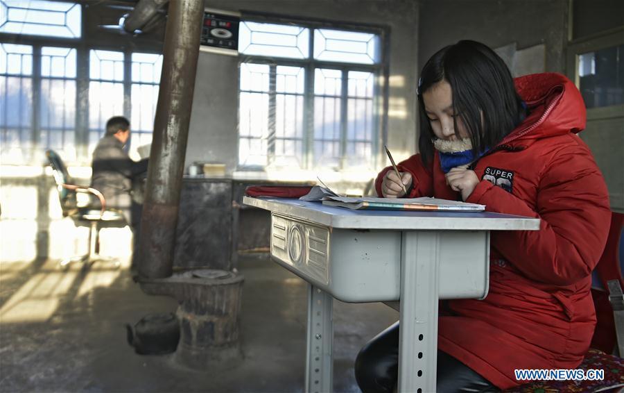Sun Xiaofeng answers exercises at Yantai primary school in Yantai Village of Lianhua Township in Tieling City, northeast China\'s Liaoning Province, Jan. 8, 2019. Located in a remote mountain village, most students of Yantai school had transferred to other places outside the mountain. Sun Xiaofeng, a third grade student, became the only student of the school in September last year taught by Hu Zhisheng, the only one faculty of Yantai primary school. (Xinhua/Yao Jianfeng)
