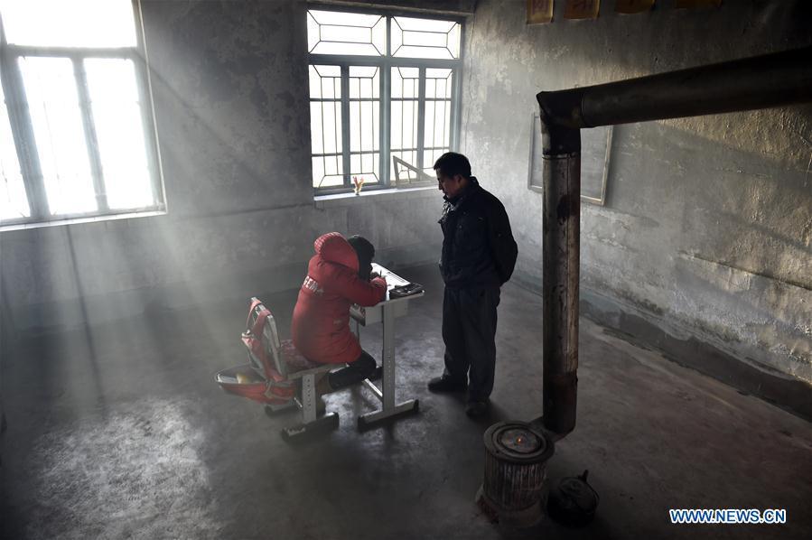 Hu Zhisheng tutors his student Sun Xiaofeng at Yantai primary school in Yantai Village of Lianhua Township in Tieling City, northeast China\'s Liaoning Province, Jan. 8, 2019. Located in a remote mountain village, most students of Yantai school had transferred to other places outside the mountain. Sun Xiaofeng, a third grade student, became the only student of the school in September last year taught by Hu Zhisheng, the only one faculty of Yantai primary school. (Xinhua/Yao Jianfeng)