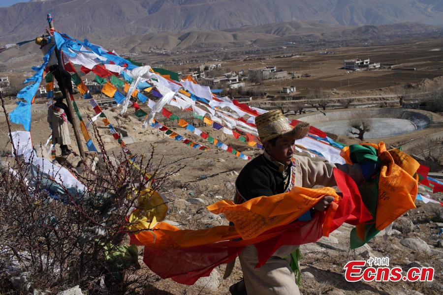 Tibetans hang prayer flags as part of celebrations for the New Year in the Tibetan calendar in Nyemo County, Southwest China\'s Tibet Autonomous region. In traditional highland barley farming areas, including Nyemo County, locals have a tradition of celebrating the Tibetan New Year one month early, so the celebrations do not affect farming. (Photo: China News Service/Sangdan Pingcuo)