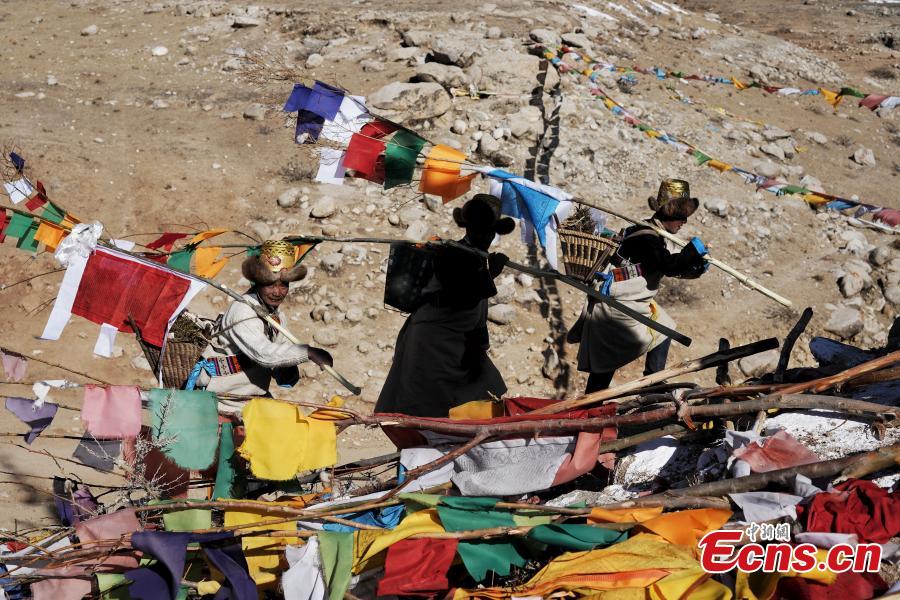 Tibetans hang prayer flags as part of celebrations for the New Year in the Tibetan calendar in Nyemo County, Southwest China\'s Tibet Autonomous region. In traditional highland barley farming areas, including Nyemo County, locals have a tradition of celebrating the Tibetan New Year one month early, so the celebrations do not affect farming. (Photo: China News Service/Sangdan Pingcuo)