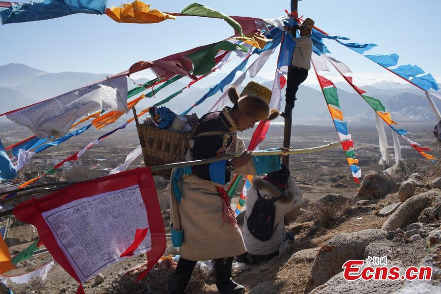 Tibetans hang prayer flags as part of celebrations for the New Year in the Tibetan calendar in Nyemo County, Southwest China\'s Tibet Autonomous region. In traditional highland barley farming areas, including Nyemo County, locals have a tradition of celebrating the Tibetan New Year one month early, so the celebrations do not affect farming. (Photo: China News Service/Sangdan Pingcuo)