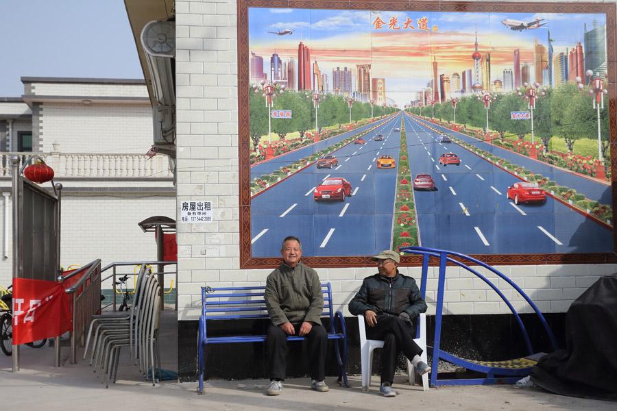 Two villagers rest in front of a tile billboard in Baita village, Rongcheng county, Xiongan New Area, on March 29, 2018. (Photo by Wang Jing/China Daily)

Creating a livable and business-friendly city

To make Xiongan an ideal area for living and working, the new area will provide quality public facilities and services for its dwellers, as well as build a shared, multilayered and comprehensive basic public service network.

The plan also emphasizes a housing system with a balance between renting and owning, and prohibits large-scale development of commercial real estate.