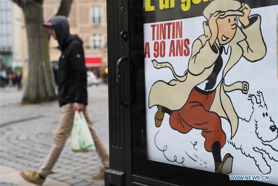 A man walks by a poster celebrating the 90th anniversary of \