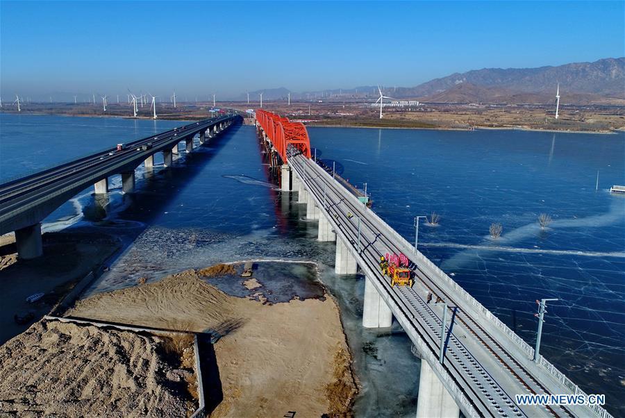 Aerial photo taken on Jan. 13, 2019 shows workers laying the tracks for the Beijing-Zhangjiakou high-speed railway line at Guanting Reservoir grand bridge in north China\'s Hebei Province. Track laying work of the Beijing-Zhangjiakou high-speed railway line at Guanting Reservoir grand bridge was completed on Sunday. The 174-km-long railway, connecting China\'s capital Beijing and Zhangjiakou of north China\'s Hebei Province, is a major transportation project for the 2022 Winter Olympic Games. (Xinhua/Yang Shiyao)