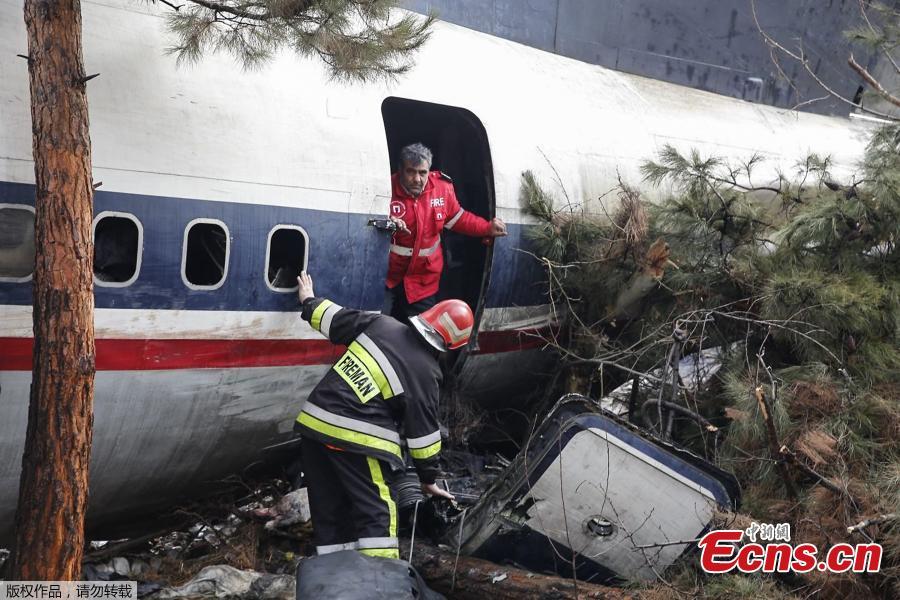 Firefighters and security forces gather amidst the debris of a Boeing 707 cargo plane that reportedly crashed into a residential complex near the Iranian capital Tehran with more than 10 people onboard on January 14, 2019. The plane overshot the runway during its landing, Iran\'s aviation organisation spokesman Reza Jafarzadeh told state broadcaster IRIB. (Photo/Agencies)
