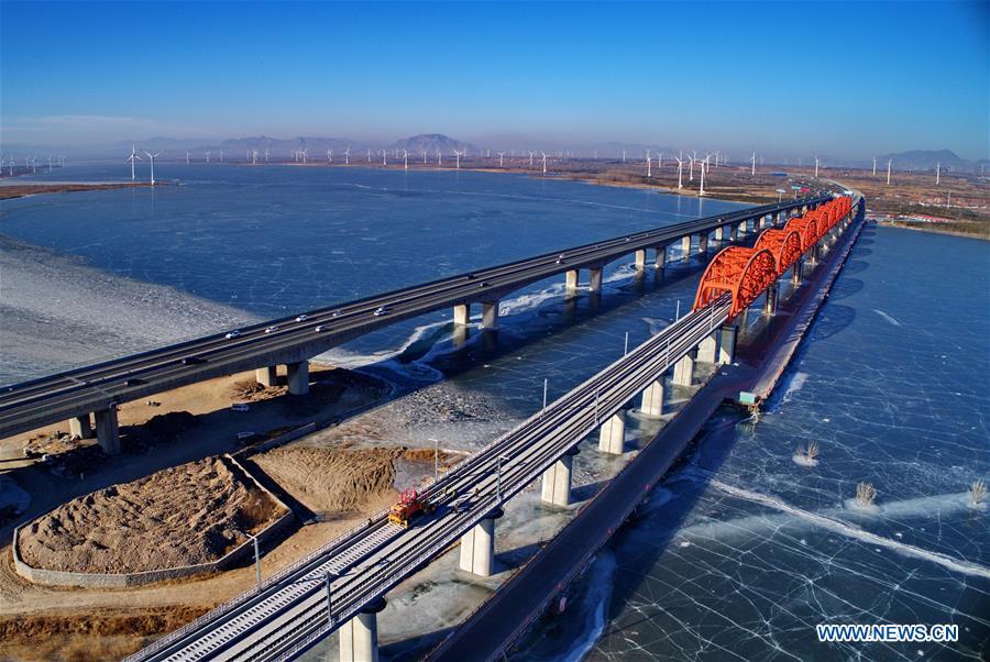Aerial photo taken on Jan. 13, 2019 shows workers lay the tracks for the Beijing-Zhangjiakou high-speed railway line at Guanting Reservoir grand bridge in north China\'s Hebei Province. Track laying work of the Beijing-Zhangjiakou high-speed railway line at Guanting Reservoir grand bridge was completed on Sunday. The 174-km-long railway, connecting China\'s capital Beijing and Zhangjiakou of north China\'s Hebei Province, is a major transportation project for the 2022 Winter Olympic Games. (Xinhua/Yang Shiyao)