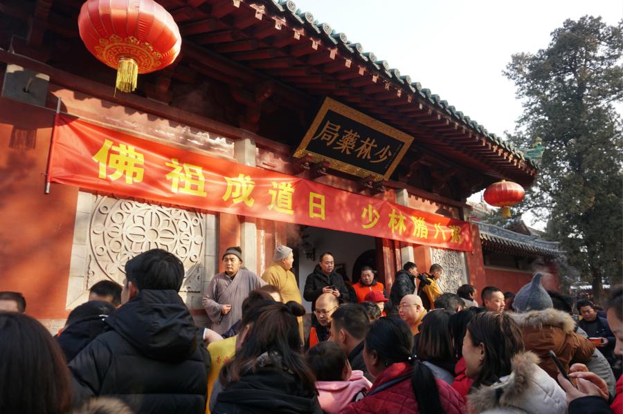 Visitors share Laba congee handed out for free during an event taking place in front of the temple\'s Shaolin Medicine health unit, Jan. 13, 2019. The congee was cooked according to a traditional recipe and included five types of beans as well as more than 20 minor ingredients. Buddhist temples across China have started handing out free Laba congee, a special meal served during the Laba Festival, which falls on the eighth day of the 12th lunar month and ushers in China\'s Lunar New Year celebrations. (Photo: China News Service/Han Zhangyun)