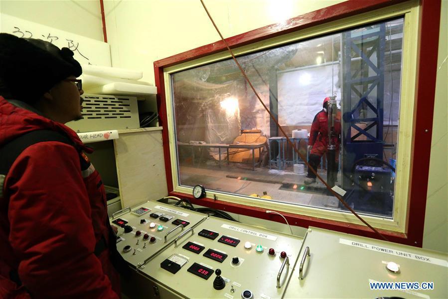 Fan Xiaopeng (L), a member of one of two inland expedition teams on China\'s 35th Antarctic expedition, operates the drilling equipment at the Kunlun Station in Antarctica, Jan. 12, 2019. (Xinhua/Liu Shiping)