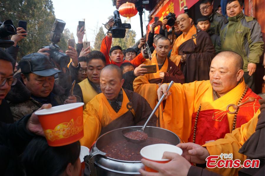 Shi Yongxin, the abbot at the Shaolin Temple, hands out Laba congee to visitors from across the country at an event taking place in front of the temple\'s Shaolin Medicine health unit, Jan. 13, 2019. The congee was cooked according to a traditional recipe and included five types of beans as well as more than 20 minor ingredients. Buddhist temples across China have started handing out free Laba congee, a special meal served during the Laba Festival, which falls on the eighth day of the 12th lunar month and ushers in China\'s Lunar New Year celebrations. (Photo: China News Service/Han Zhangyun)