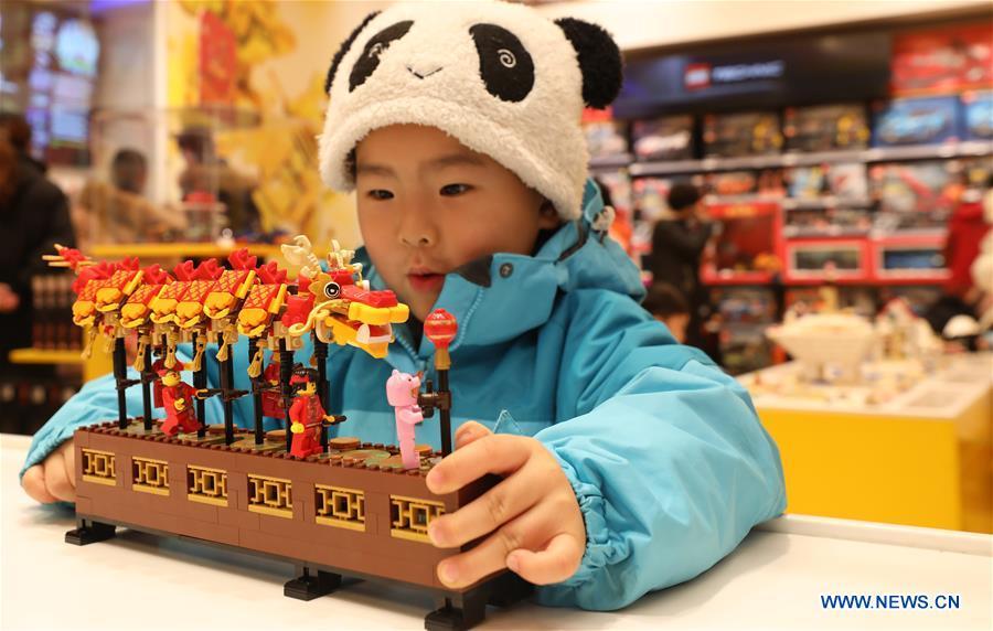 A child plays toy bricks under the theme of dragon dance to coincide with the Spring Festival at a store in east China\'s Shanghai, Jan. 14, 2019. (Xinhua/Fang Zhe)