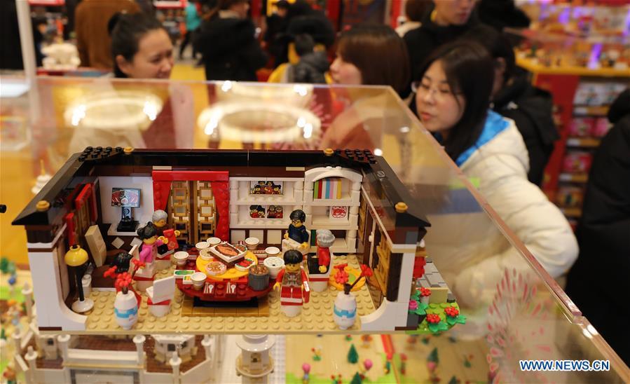 Customers walk past toy bricks under the theme of new year\'s eve dinner to coincide with the Spring Festival at a store in east China\'s Shanghai, Jan. 14, 2019. (Xinhua/Fang Zhe)