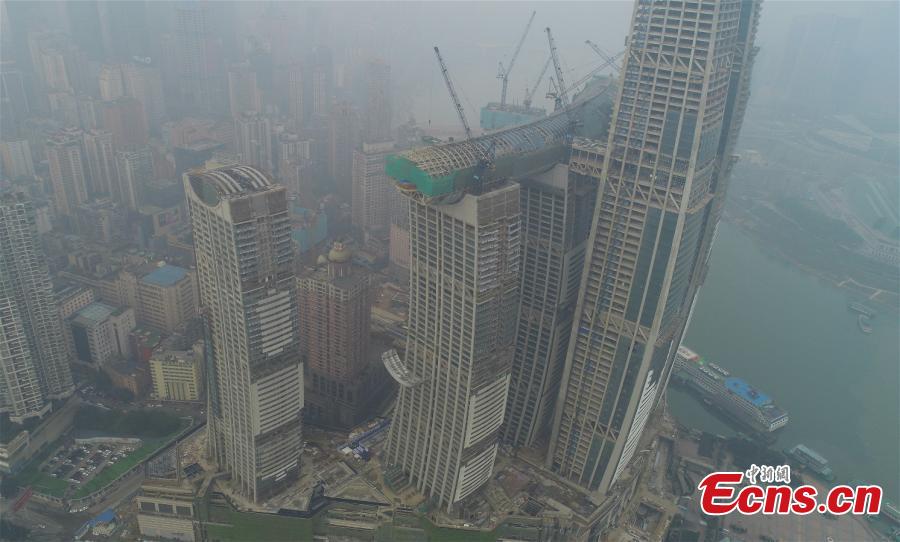 Core construction work on a 300-meter-long conservatory, part of the Raffles City Chongqing complex, is complete in Southwest China\'s Chongqing, Jan. 14, 2019. Located at the confluence of the Yangtze and Jialing rivers, Raffles City Chongqing has been designed by world-renown architect Moshe Safdie, who drew inspiration from the region\'s thousand years of waterway transportation history. The conservatory, 32.5 meters wide and 26.5 meters tall, connects the tops of four buildings, 250 meters above the ground, as well as accommodating a viewing deck, an infinity pool, a sky walk and varied dining options. (Photo provided to China News Service)
