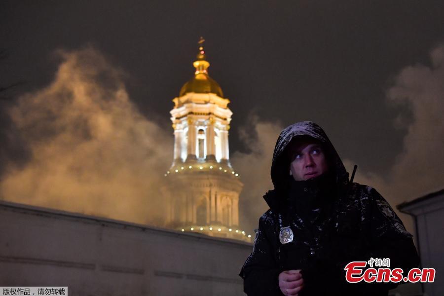 A policeman stands guard as firefighters try to extinguish a fire in one of the historic building of Kiev Pechersk Lavra, an historic Orthodox Christian monastery in the Ukrainian capital of Kiev on Jan. 14, 2019. According to the State Emergency Service\'s Kiev Department, there are no victims. Since its foundation, the Lavra has been a preeminent center of Eastern Orthodox Christianity in Eastern Europe and is one of the first to establish monasteries of Kievan Rus. (Photo/Agencies)