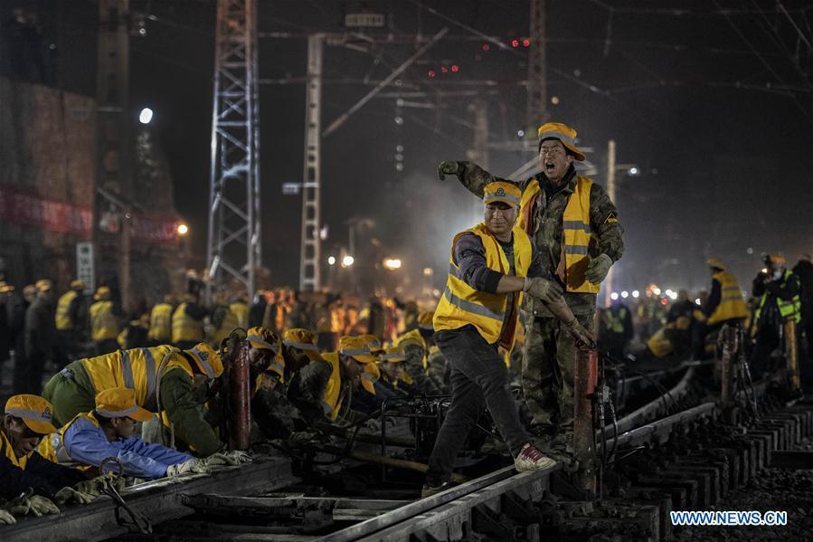 Workers connect rails on the construction site of Xi\'an Railway Station in Xi\'an, capital of northwest China\'s Shaanxi Province, Jan. 15, 2019. After six hours of continuous overnight work of 1,000 plus workers, the reconstruction and extension project of the Xi\'an Railway Station entered the phase of main project construction on Tuesday, which laid a solid foundation for the upcoming Spring Festival travel rush. (Xinhua/Tao Ming)