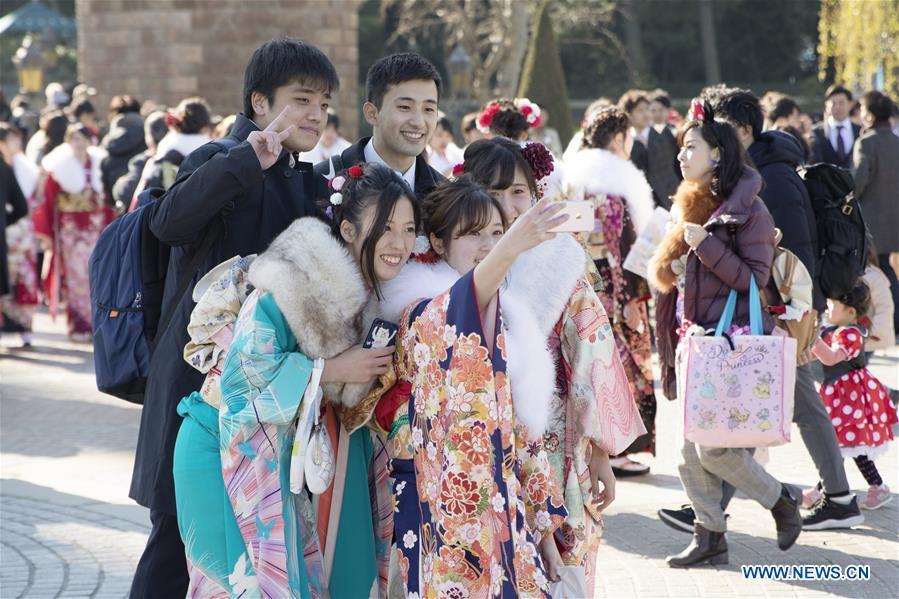 Japanese boys and girls take selfies to celebrate Coming of Age together at Tokyo Disneyland in Chiba, Japan, Jan. 14, 2019. People who turned 20-year-old took part in the annual Coming of Age Day ceremony in Japan on Monday. (Xinhua/Du Xiaoyi)