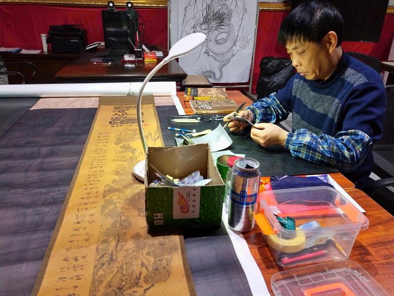 Gao Baoan works on his can-made replica of Riverside Scene at Qingming Festival. (Photo provided to chinadaily.com.cn)